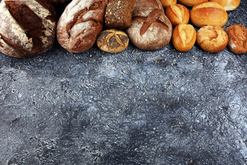 Different kinds of bread and bread rolls on board from above. Kitchen or bakery poster design