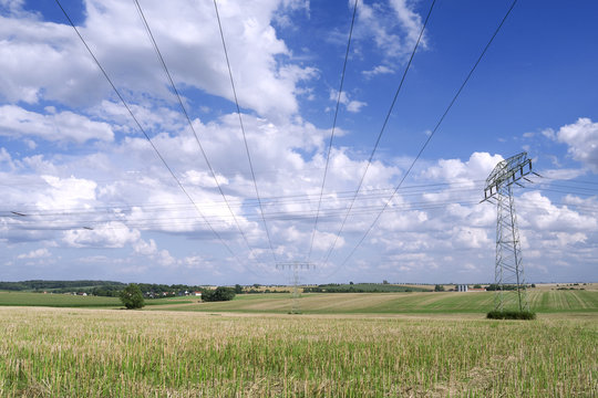 Power Lines: A 110 KV and a 220 KV high-voltage power line crossing over a stubblefield in Eastern Thuringia