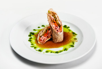 meat rolls on a plate with sauce, and greens