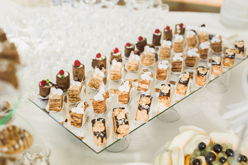 Delicious sweets on wedding candy buffet with desserts, cupcakes