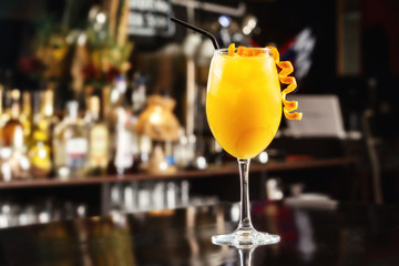 Closeup glass of orange screwdriver cocktail at bar counter background.