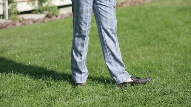Elegant Male Shoes walking on green park grass.