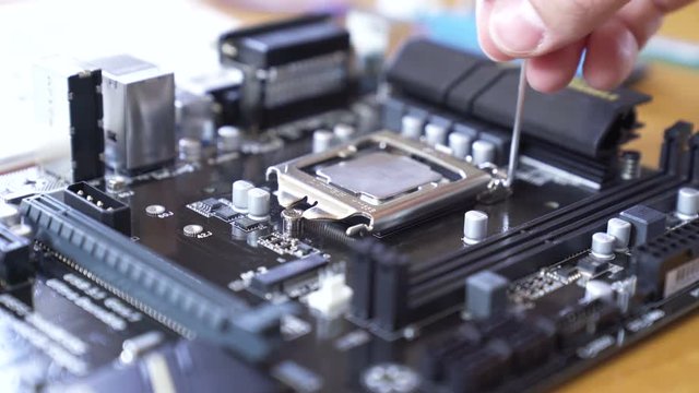 Engineer sets the CPU into the motherboard. Close up 4K shot.