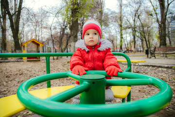 Fototapeta na wymiar the child is spinning on a swing in the playground in the park