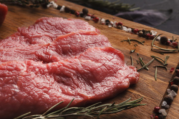 Raw beef filet mignon steaks on wooden board