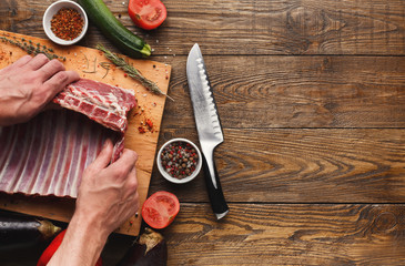 Chef cutting rack of lamb on wooden board