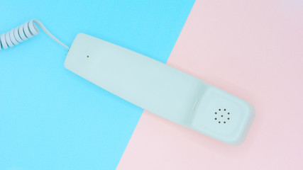 telephone receiver on blue and pink background