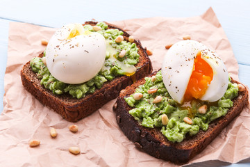 breakfast bruschetta with avocado and spinach and poached egg. with a cup of coffee