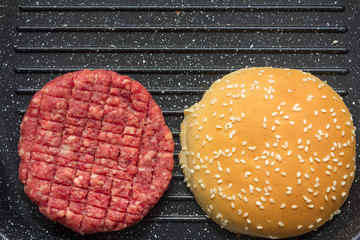 raw burger in grill pan 