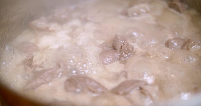 Boiling lamb meat in a saucepan