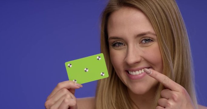 Close Portrait of a Woman holding a blank Credit Card and making thump up