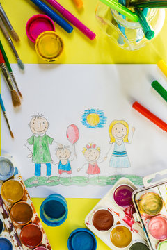 Childrendrawing pencil happy family mom, dad, son, daughter sunny day on the lawn and paint accessories, brush, felters gouache, watercolor on a yellow  background flat  lay top view from above