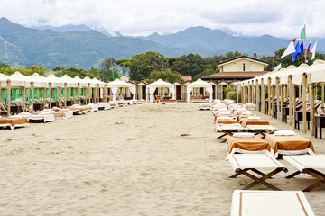 Daylight view to beige sunchairs and sunshades on beach