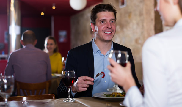 Male with female colleague on friendly meeting over dinner