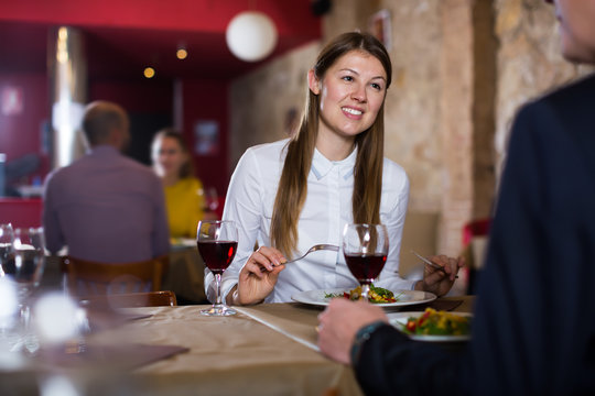 Young girl with man enjoying meal at restaurant
