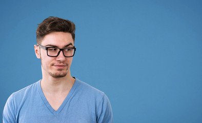 male in glasses with skeptic look, raises eyebrow in bewilderment