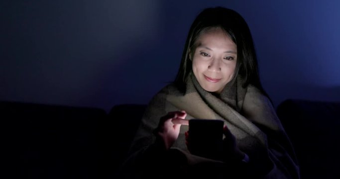 Woman work on mobile phone at night