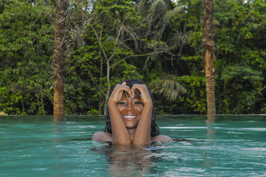 Young Attractive Happy Black African American Woman Enjoying Holidays In Tropical Resort Infinity Pool To Beautiful Jungle Landscape With Palm Trees