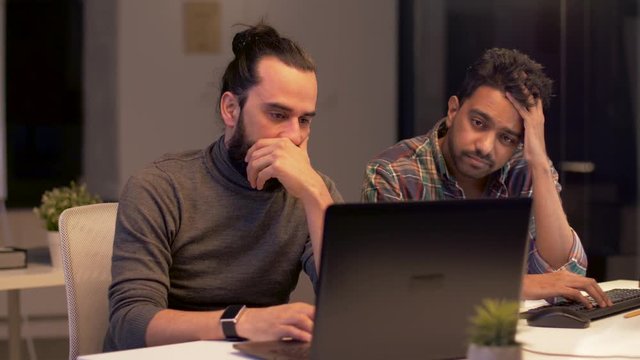 deadline, technology and people concept - creative team with computers working together late at night office