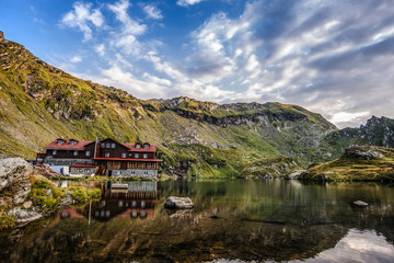 Fototapeta na wymiar house situated on a foot of the mountain near the lake