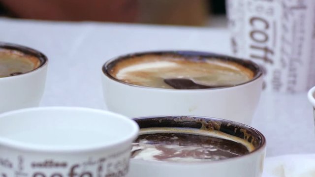 Barista removes foam from the surface of hot natural coffee.