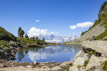 Fototapeta na wymiar Mirror reflectons of mountain range Dachstein in lake Spiegelsee Mittersee