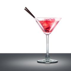 Cosmopolitan cocktail in martini glass with tube isolated on mirror table and place for inscription. Clipping path