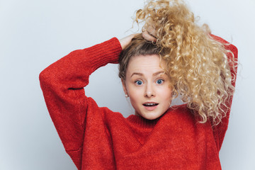 Emotional surprised female strares at camera with unexpected look, keeps hair in pony tail, expresses surprisment, isolated over white studio background. It`s unbelievable! Amazement and shock