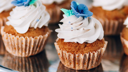 muffins with whipped cream and frosting on a silver table in stainless steel