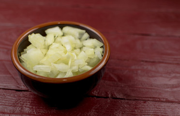 The chopped onion in a cup is filled with boiling water.