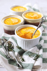 Dietetic food. Four servings of carrot flan on light background