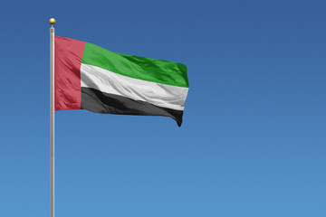 Fototapeta na wymiar Flag of United Arab Emirates in front of a clear blue sky