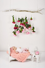 Newborn baby girl in pink ribbon lies at a bed