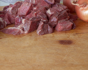 Raw meat is sliced for cooking.