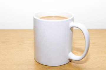Cup of tea in a white mug with milk