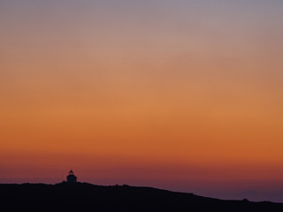 A small chapel on top of the hill at sunset
