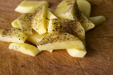 Raw potatoes sliced for cooking French fries in a rustic manner.