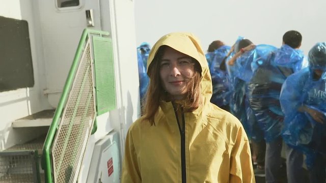 Girl in yellow raincoat Standing on a ship at Niagara Falls. Not like other. With eyes closed. Close-up portrait. Slowmotion