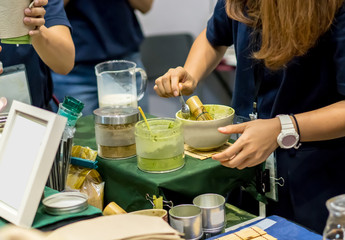 Woman hands showing technique of Matcha green tea beverage preparation