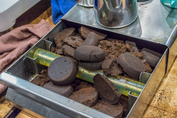 Closed up lumps of coffee grind filled on metal knock box