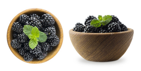 Blackberries in a wooden bowl with copy space for text. Ripe and tasty black berry isolated on white background.