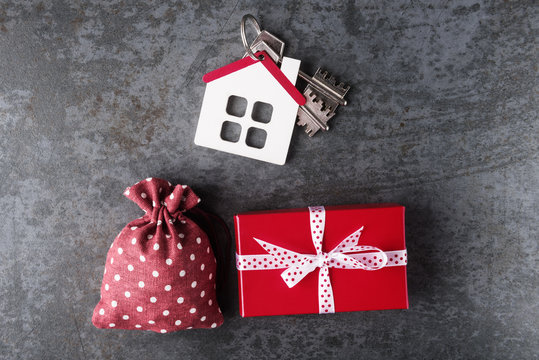 Red Canvas Bag, Gift Box And House Model On Stone Background.