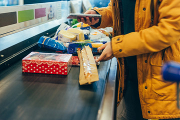 woman put products on cash line in store. grocery shopping.