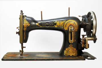 An old antique sewing machine, decorated with golden ornaments
