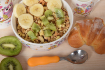 background for children's breakfast with muesli and fruit, croissant and kiwi
