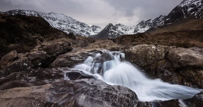 Time lapse clip of waterfall at Fairy pools and snowcapped Cuillin range in Isle of Skye, Scotland.