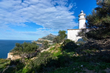 Fototapeta na wymiar White lighthouse in northwest Mallorca between mountains. Mediterranean Sea. Seascape