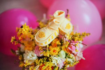 Spring flowers and  baby shoes. Magic Easter