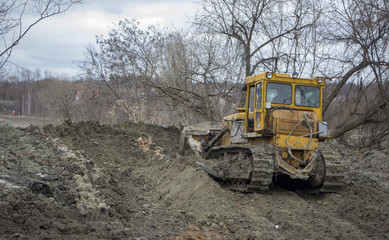 Obraz premium A large bulldozer digs a reclamation channel
