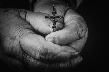 Obraz premium he cross is in the hands of the old man.